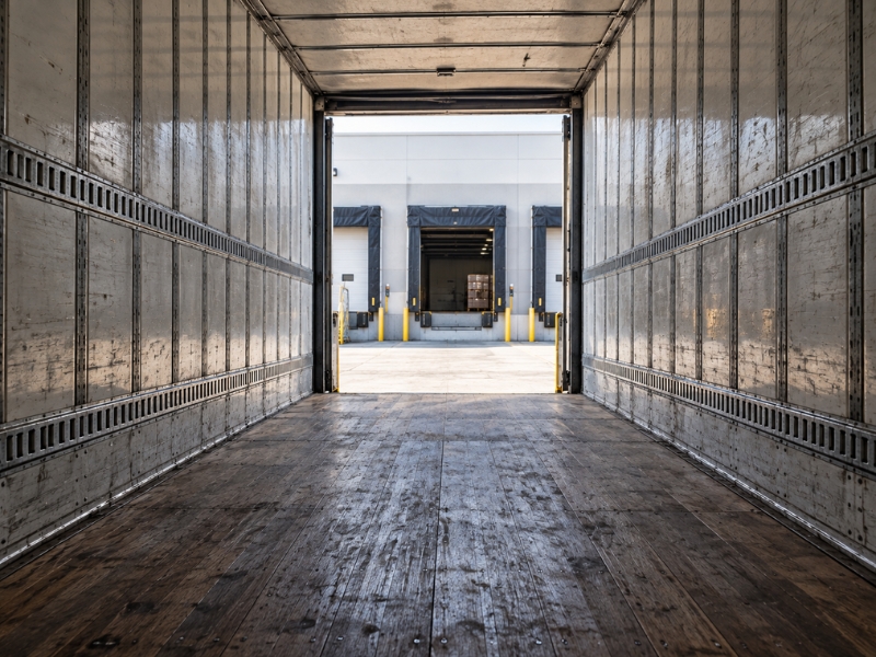 Inside a 53-foot dry van trailer showing enclosed cargo space, interior walls and tie-down rails